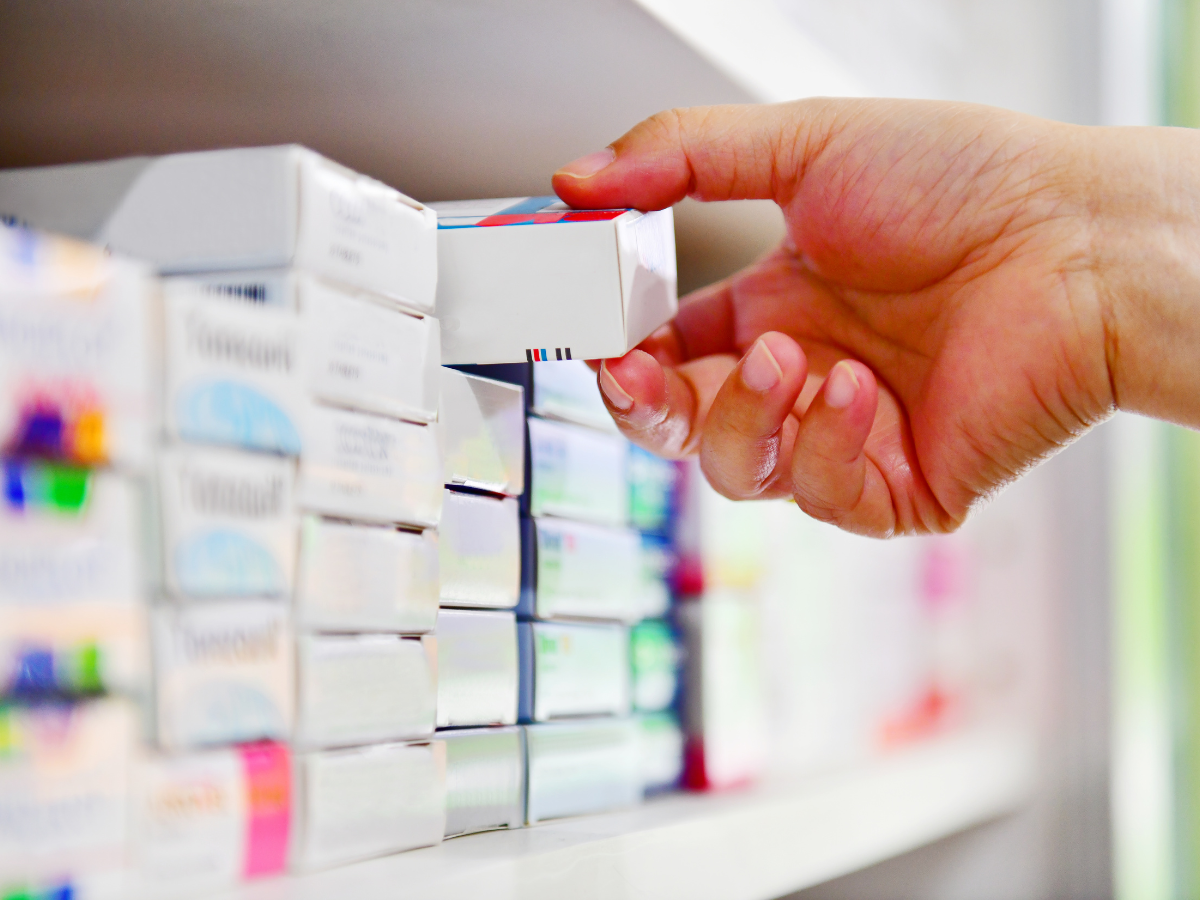 A person holding a box of pills